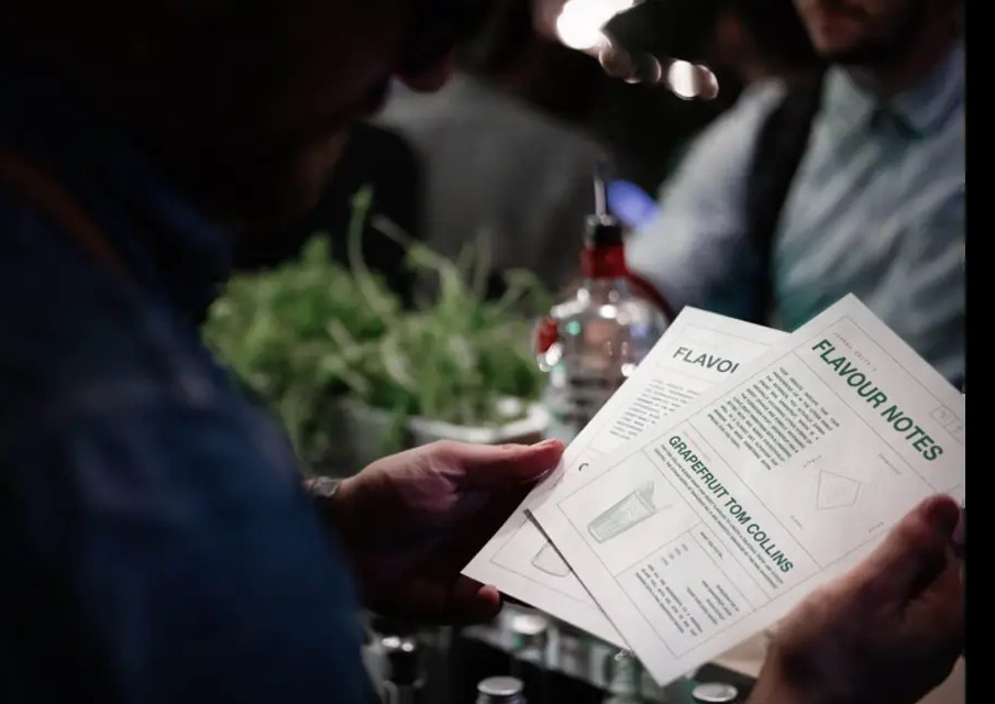 Guest reading Tanqueray flavour notes at the bar